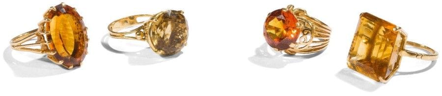 Suite de 4 bagues en fils d’or jaune 18K (750‰), dont 3 ornées de citrines, la dernière d’un corindon orange synthétique. 
Poids brut : 36,7 g