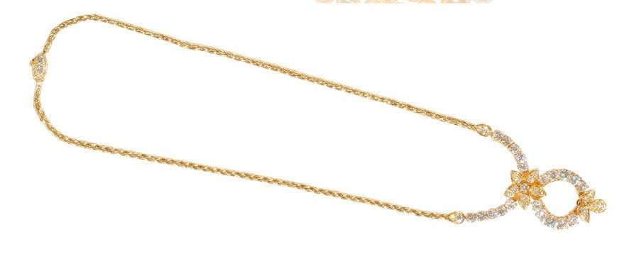 Collier en or jaune 18K (750‰), centré d’un motif floral serti de diamants, le fermoir agrémenté de diamants plus petits.
Long. : 39,6 cm environ. 
Poids brut : 27,3 g