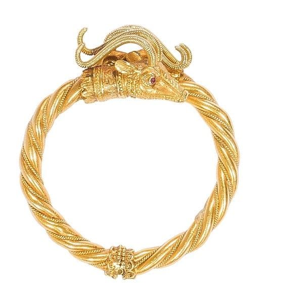 LALAOUNIS. Bracelet ouvrant en or jaune 18K (750‰) torsadé, les extrémités sculptées en protomés de gazelles, les yeux piqués d’un rubis. Signé. 
Poids brut : 79 g