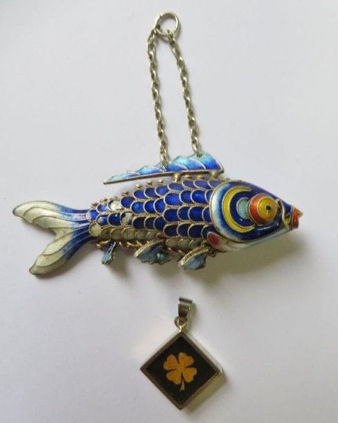 Suite de deux chaînes en or gris 18K (750‰). 
Poids brut : 19,6 g (accident, fermoir en argent). 
On joint une paire de boucles d’oreilles ornées d’une perle de culture, un poisson émaillé en pendentif et un trèfle à 4 feuilles fantaisie.
