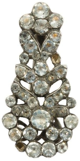 Busquière en argent à motif floral stylisé, sertie de strass. 
Travail du dernier tiers du XVIIIe siècle.
Haut. : 4,5 cm environ. 
Poids brut : 17,3 g (manques)