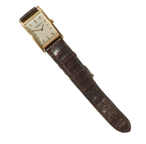 JEAGER LECOULTRE. Montre d’homme rectangulaire en or 18K (750‰). Cadran peint argenté, aiguilles-baguettes, verre ceintré. Fond plat tenu par des vis. Boîte numérotée 144669. Bracelet en cuir.
Poids brut : 26,50 g