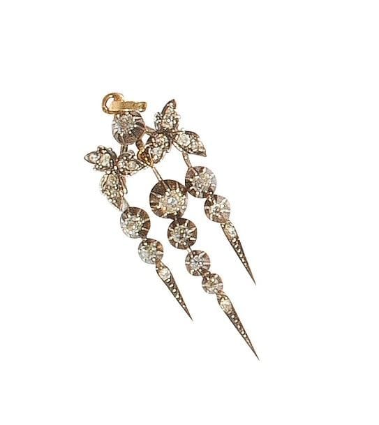 Pendentif en argent et en or 18K (750‰) en motif floral stylisé, orné de diamants de taille ancienne et taillés en roses.
Travail français du XIXe siècle.
Haut. : 5,5 cm environ.
Poids brut : 6,4 g
