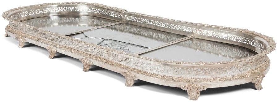 Grand surtout en trois parties à galerie ajourée à décor de feuillages en métal doublé, sur son parquet d’origine, accident à un miroir.
PARIS entre 1829 et 1840
Orfèvre : Charles BALAINE
Longueur : 132 cm - largeur : 56 cm - hauteur : 11 cm
