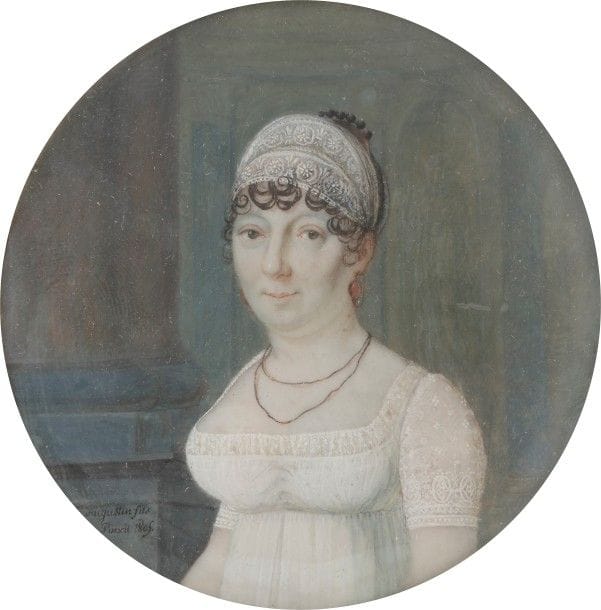 Charles-Henry AUGUSTIN, dit AUGUSTIN fils ou neveu (Dijon, 1779-Paris, 1819)
Femme vue dans un intérieur luxueux de l’époque Empire, en robe de dentelle blanche et bandeau assorti dans ses cheveux bouclés, à mi-corps vers la gauche. 
Miniature sur ivoire, époque Empire 
Signée et datée en bas à gauche sur la base de la colonne : Augustin fils/ pinxit 1805
Diam. à vue 6 cm
Cadre en bois noirci, rectangulaire 12,5 x 11,6 cm
Le portrait est pris dans l’une des résidences impériales ou un luxueux hôtel particulier de l’époque Empire, au décor architecturé : à gauche des colonnes monumentales jumelées, et à droite, on devine au fond la statue d’un empereur romain dans une niche, et des pilastres bleutés.
Augustin fils, fils d’Augustin Dubourg et neveu du célèbre Jean-Baptiste-Jacques Augustin, fut peintre en miniature et de silhouettes mais aussi un aéronaute chevronné qui fit des expériences en ballon. Son œuvre de peintre en miniature, très oublié, est à reconstituer.
