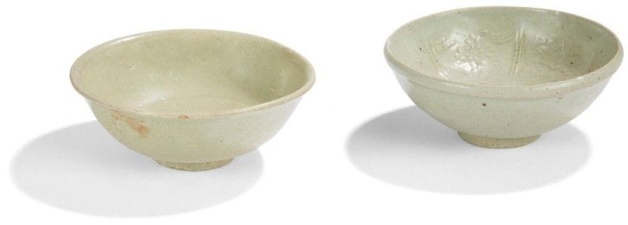 CHINE, Fours de Longquan - Époque MING  (1368 - 1644)
Deux bols en grès émaillé céladon à décor moulé sous la couverte de pivoines, lotus et chrysanthèmes pour l’un, et d’une fleur de lotus pour l’autre. (Egrenures). Diamètre : 16,5 et 17 cm