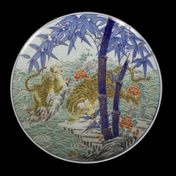 JAPON, Imari - Époque MEIJI (1868 - 1912)
Grand plat en porcelaine décorée en bleu sous couverte et émaux polychromes d’un couple de tigres près de bambous. Au revers, la marque apocryphe de Chenghua. (Fêlure). Diamètre : 46 cm