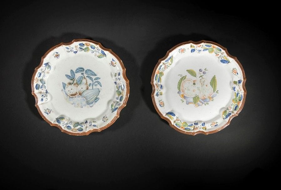 Nove di Bassano
Deux assiettes à bord contourné en faïence à décor polychrome de fruits sur des rinceaux rocaille au centre et de tiges fleuries sur l’aile.
XVIIIe siècle. 
D. : 23 cm.
Egrenures.