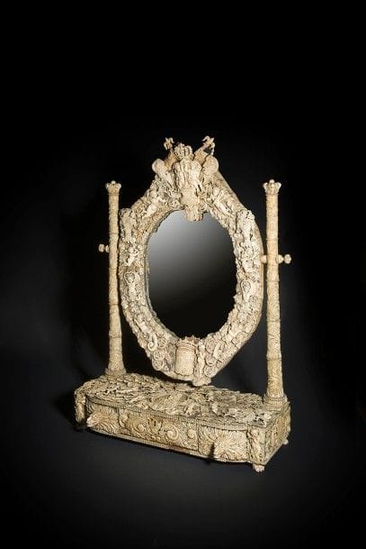 Grand miroir de toilette en ivoire et os sculpté, le cadre mobile à deux montants reposant sur une base ouvrant à trois tiroirs, riche décor de rinceaux et amours dans le goût du XVIIe siècle, armes et couronne royales, portrait de Louis XIV inscrit Ludovicus XIV Rex ; fragment du catalogue de la vente Monk collé au revers.
Dieppe, Milieu du XIXe siècle.
H : 87 cm, L : 62 cm, P : 28 cm

Provenance :
Ancienne collection Frederick Alfred Monk (1864-1944)