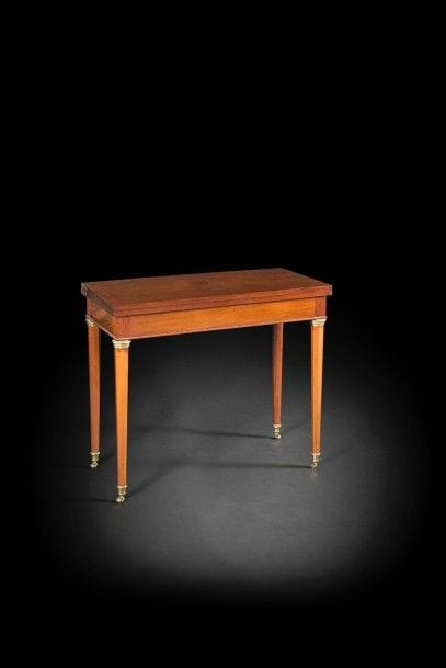Table à jeu en acajou flammé et mouluré, le plateau à volet et le piétement coulissant, reposant sur des pieds fuselés à pans coupés à chapiteau et sabots.
Époque Louis XVI.
H : 74 cm, L : 85 cm, P : 42 cm