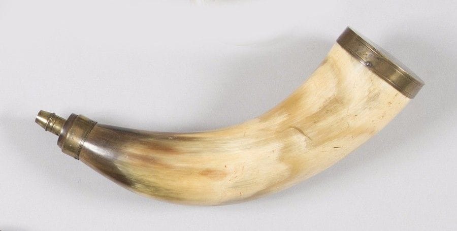 Corne à poudre de chasse en corne blonde à deux anneaux de suspente. 
Bec et garnitures en laiton. 
B.E. XIXe siècle. 