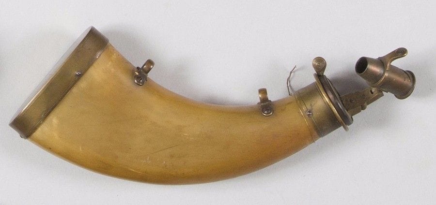 Poire à poudre de chasse en corne blonde, à deux anneaux de suspente. 
Bec doseur sur rotule et garnitures en laiton. 
B.E. XIXe siècle. 