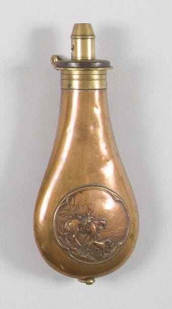 Poire à poudre à un anneau de suspente, en cuivre rouge, à décor d’un chasseur avec son cheval et son chien. 
Bec doseur en laiton. 
B.E. XIXe siècle. (Légers coups d’usage). 