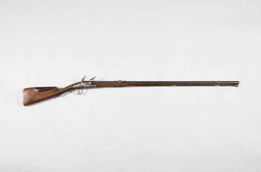 FUSILS DES CHASSES ROYALES 
Long et fin fusil à silex des Chasses royales aux Armes du comte d’Artois, frère du roi, par Allevin Arquebusier de Monsieur. 
Canon rond, patiné, à méplat sur le dessus, à pans au tonnerre, ciselé sur le dessus de colonnes fleuries, d’un trophée, de nuage, d’urne enflammée et d’une fleur de lys rayonnante sur monogramme « JA » de l’arquebusier Allevin. Queue de culasse gravée en suite. Surmonté d’un large cran de visée en argent ciselé et découpé, orné de bouquets, gravé d’un soleil à visage d’enfant. Point de mire en argent. Platine gravée de rinceaux et signée « Allevin Arquebusier de Monsieur Frère du Roi A Paris » et chien col de cygne à corps rond. Bassinet rond en fer. Superbes garnitures en argent découpé et ciselé en fort relief. Pontet orné d’un trophée d’armes et sur le devant d’une urne fleurie, trophée d’arme et fleurs. Numéroté sur la queue de pontet « 5 », ciselé en suite de fleurs et feuillages. Plaque de couche à bords mouvementés décorés en suite. Monture en noyer. Crosse à joue en maroquin bordé d’un galon argent. Col de crosse sculpté portant incrustée une pièce en argent gravée des Grandes Armes du comte d’Artois. 
Long fût sculpté à entrée et deux porte baguette en argent. Baguette en fanon à embout en corne marbrée. 
Poinçon d’argent « A » sous couronne (Paris, 1764). 
Longueur : 130 cm
B.E. Vers 1780. 

Jean Baptiste Claude ALLEVIN, arquebusier du Roi et de Monsieur, vers 1760-1780. Il fut également arquebusier de la capitainerie royale des chasses du Louvre. Ses armes sont toujours d’une grande qualité. 
Charles Philippe (1757-1834) comte d’Artois, puis Charles X, roi de France (1824-1830). Petit-fils de Louis XV, frère de Louis XVI et de Louis XVIII, Charles Philippe porte avant son accession au trône le titre de comte d’Artois. De son mariage (1773) avec Marie-Thérèse de Savoie, il a eu trois enfants, dont le duc d’Angoulême et le duc de Berry. Viveur fastueux et impopulaire, il se met