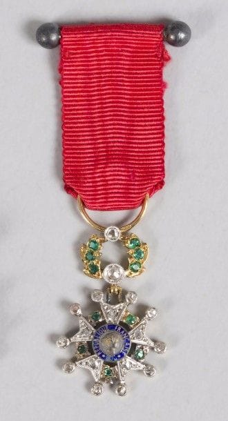 FRANCE 
ORDRE DE LA LÉGION D’HONNEUR, institué en 1802. 
Étoile de chevalier miniature d’époque 
IIIe République, modèle de luxe. 
Or et émail, garnie de roses. 
Hauteur : 4,5 cm - Poids brut : 2,8 g
T.T.B. 