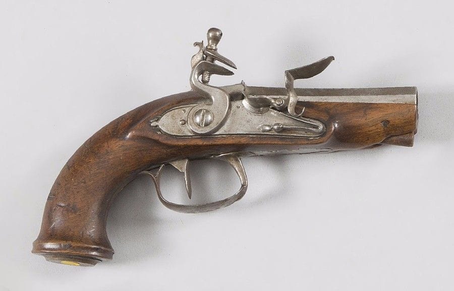 Petit pistolet à silex de voyage. 
Canon à pans. Platine et chien col de cygne à corps plat. Garnitures en fer découpé. Crosse en noyer. 
A.B.E. (Accident mécanique). Vers 1760-1780. 
