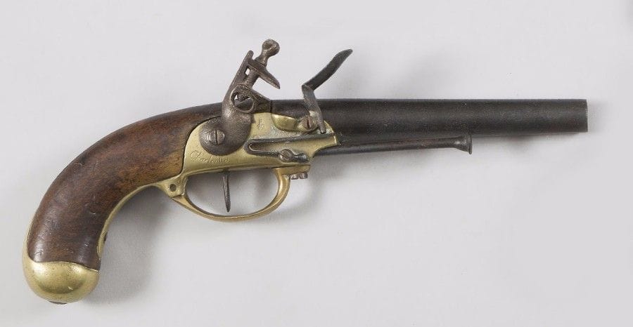 Pistolet d’arçon à silex modèle 1777. 
Canon rond frappé au tonnerre « 81 ». Coffre en bronze gravé « MAUBEUGE » et poinçonné. Garnitures en laiton. Crosse en noyer. Baguette et crochet de ceinture en fer. 
B.E. (Crochet postérieur). 