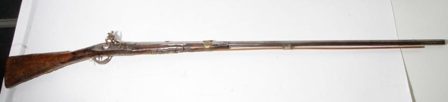 Fusil de chasse à silex. 
Canon rond à pans, gravé et poinçonné au tonnerre. Platine et chien col de cygne gravés. Ressort à roulette. Garnitures en laiton ornées de masques en argent. Crosse en noyer. E.M. Italie. Vers 1780. (Usure, accident au fût).
