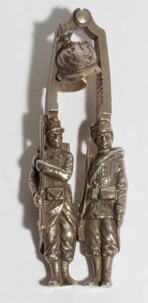 Casse-noix en métal argenté à prises en soldats français et russes, écrasant un casque à pointe. 
B.E. Vers 1914. 