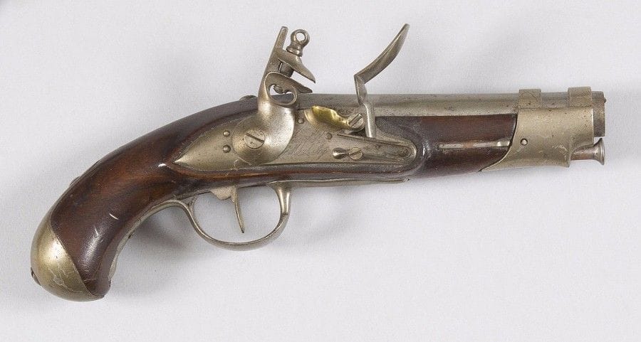Pistolet de gendarmerie modèle An IX à silex.
Canon rond à méplats au tonnerre, daté « 1817 ». Queue de culasse gravée « M. an 9 ». Platine gravée « Manufre Royle de Maubeuge ». Chien à corps rond. Garnitures en fer poinçonné. Crosse en noyer. Baguette en fer.
B.E.