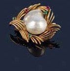 Broche stylisant un coeur en fils d'or, ornée au centre d'une perle baroque, partiellement sertie de rubis et émeraudes. Poids brut : 15 g