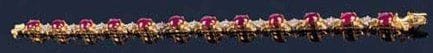 Bracelet articulé en or jaune 14kt 585 millièmes orné de 12 rubis cabochons alternés de motifs sertis de petits diamants. Longueur : 17 cm. Poids brut : 15 g
