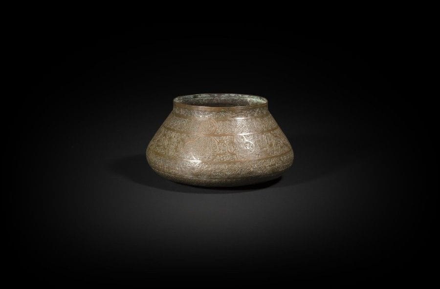 Bassin en cuivre, Syrie, déb. du XXe siècle  
Panse tronconique à décor tapissant incisé de registres de médaillons, dont trois inscrits des noms de Dieu, les autres meublés d’entrelacs géométriques et végétaux.
Haut. : 13,5 cm ; diam. ouverture : 16,5 cm
État : restaurations
 A copper bassin, Syria, early 20th century