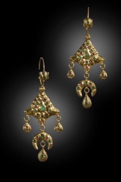 Pendants d’oreilles en or, Maroc, Fès ou Meknès, XXe siècle
Paire de boucles d’oreilles composée d’une mandorle fleuronnée et d’un croissant à pendant en goutte serti de pierres précieuses.
Long. totale : 9 cm  
P. 18 g
A pair of golden earrings, Morocco, Fez or Meknes, 20th century 