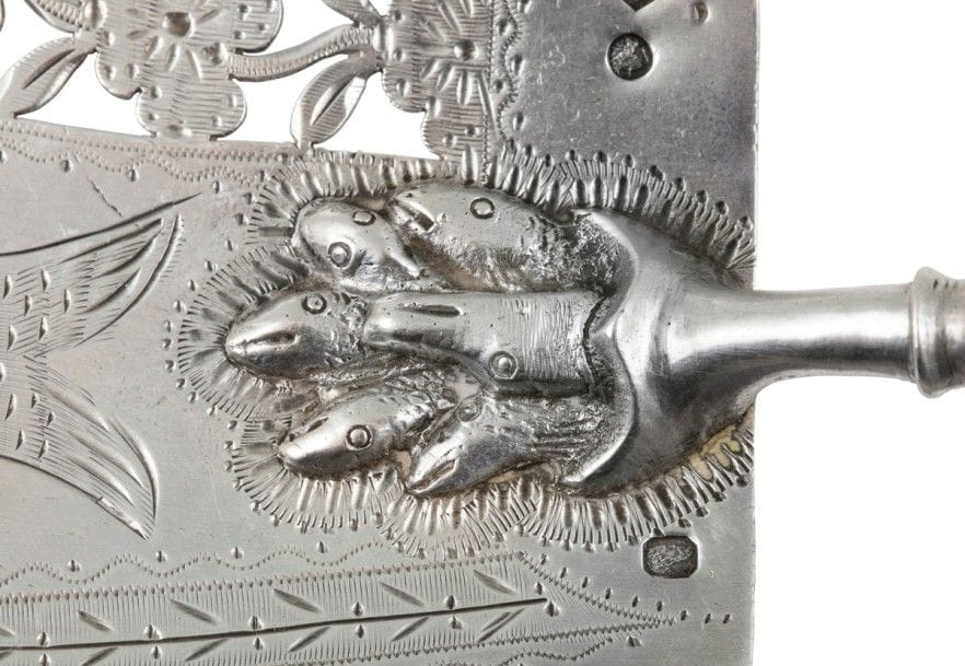 Amusante pelle à poisson en argent et manche en bois tourné. La hotte est terminée par une attache représentant des poissons pris dans une nasse, la pelle est ciselée d’un décor découpé de fleurs et de la représentation d’un poisson en son centre. Petit manque au bout du manche en bois.
PARIS 1819 - 1838
Orfèvre : François-Pamphile JOSAN, insculpe en 1824
Poids brut : 150,69 g - longueur : 36,5 cm