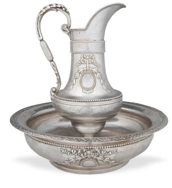 Aiguière et son bassin en argent, le bassin de forme ronde est bordé de tores laurés, il reçoit sur le corps en applique un médaillon perlé non gravé entouré de nœuds, décor que l’on retrouve sur l’aiguière reposant sur un large piédouche. 
Numérotés 1477.

Poinçon minerve, XIXe siècle
Orfèvre : ODIOT à PARIS, poinçon d’orfèvre et en toutes lettres pour les dates 1825 - 1894.

Poids : 3792 g - diamètre du bassin : 41 cm - hauteur de l’aiguière : 39 cm