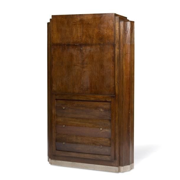 Louis SOGNOT (1892-1970) attribué à
Rare secrétaire, en placage de bois exotique teinté, ouvrant par trois tiroirs, à la façade accordéon, et par un abattant découvrant un intérieur muni d’étagères et de niches. Les côtés présentent une large demi-colonne, à très importantes cannelures, sommée d’un décor sculpté dans le goût de l’Egypte antique. Base socle plaquée de métal nickelé. État d’usage. Vers 1925. 179x108x49?cm
Bibliographie?: Intérieurs en couleurs à l’Exposition des Arts décoratifs 1925 – Préface de Léon Deshairs, éditions Albert Levy, Paris, 1925. Œuvre en rapport figurant sur la reproduction, à la planche 35, d’une aquarelle réalisée par Boris Gosser illustrant le boudoir présenté par Louis Sognot lors de la manifestation éponyme.
