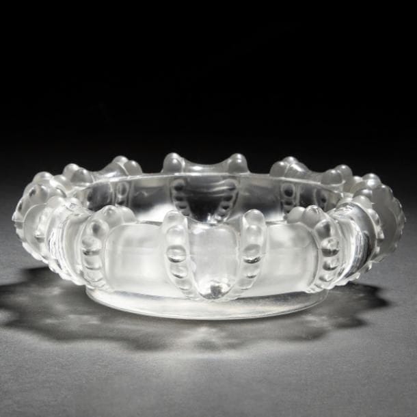 LALIQUE France d’après un modèle de Marc LALIQUE (1900-1977)
Cannes, modèle créé en 1953 
Cendrier. Épreuve en cristal moulé-pressé et, en partie, satiné. Un infime éclat sous la base. Signé LALIQUE France à la pointe sous la base. D. 19?cm
