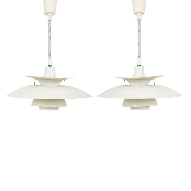Poul HENNINGSEN (1894-1967) Designer & Louis POULSEN Éditeur
Charlottenborg PH 5, modèle créé en 1926. 
Paire de suspensions, chacune composée de disques incurvés concentriques et de dimensions diverses, en métal laqué blanc, bleu et rouge à l’intérieur. Usures et torsions de certaines coupes en métal. D. 50?cm