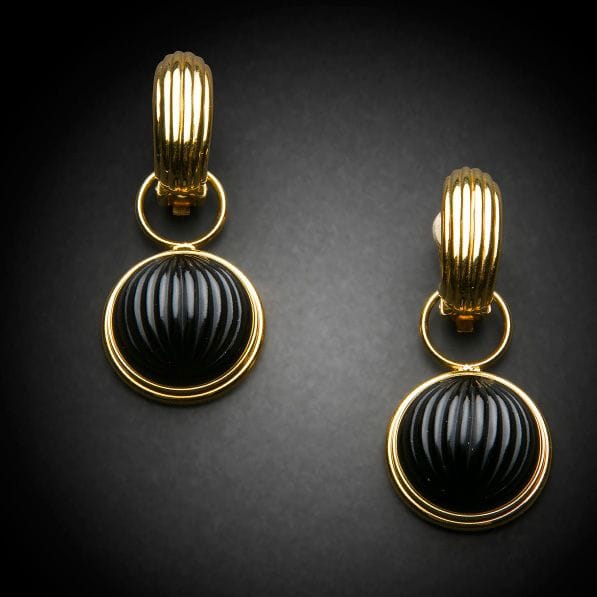 Maison LALIQUE d’après un modèle de Marie-Claude LALIQUE (1935-2003)
Cabochon 
Paire de pendants-clips d’oreille en cristal noir et métal doré. Chaque clip signé LALIQUE France au revers de la platine. D. 2,5?cm
