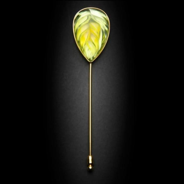 Maison LALIQUE d’après un modèle de Marie-Claude LALIQUE (1935-2003)
Épingle à chapeau en cristal vert clair strié sur monture en métal doré. Signée LALIQUE France au revers de la platine. L. 13?cm

