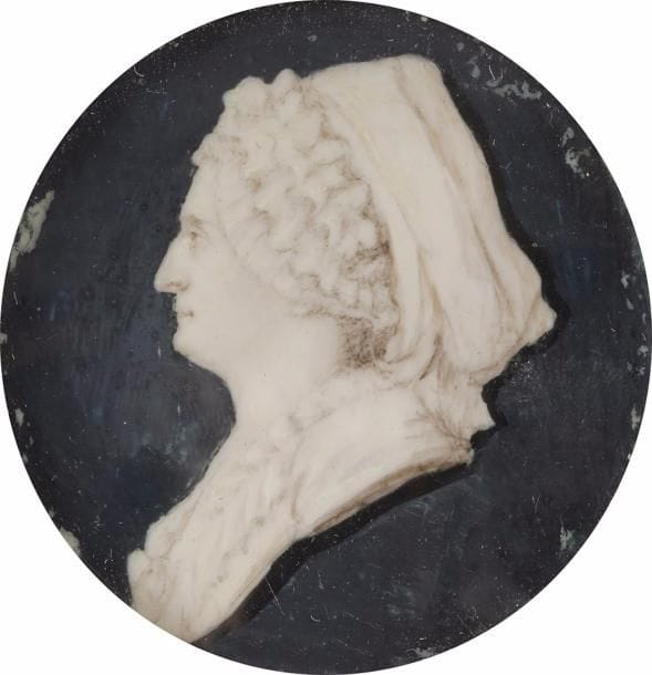 École de Piat-Joseph Sauvage (1744 - 1818).
Femme de profil à gauche en grisaille sur fond bleu en imitation de camée, coiffée d’un grand foulard sur son bonnet de dentelle.
Miniature du XVIIIe siècle, diam. 5 cm
Dans un médaillon en métal doré, XIXe siècle, diam. 5,7 cm