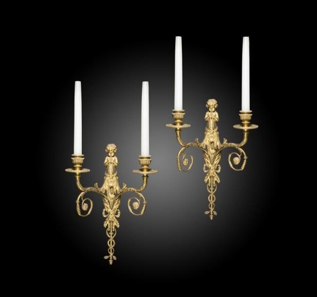 Paire d’appliques aux enfants souffleurs, à deux lumières en enroulement et le fût feuillagé.
Style Louis XVI.
H : 43 cm
