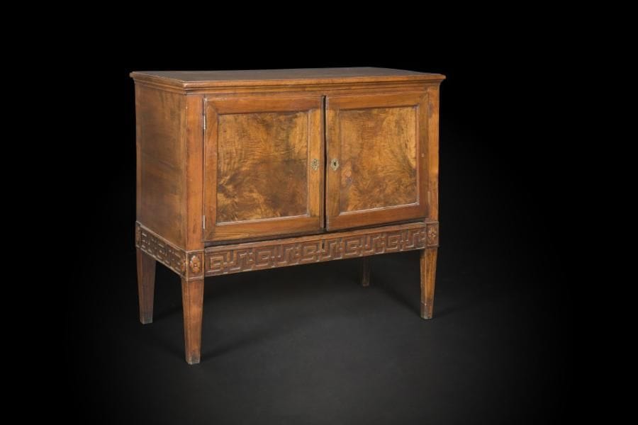 Commode à portes en noyer mouluré, les pieds en gaine réunis par une frise de grecques.
Fin du XVIIe siècle (accidents et restaurations).
H : 84,5 cm, L : 91 cm, P : 46 cm
