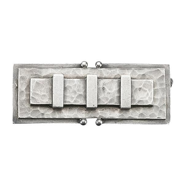 Jean DESPRÉS (1889-1980)
Rare broche moderniste en argent.
La grande base rectangulaire, à deux échancrures centrales ornées de petites sphères, reçoit une platine en léger ressaut, entièrement martelée, accueillant le décor d'une large barrette maintenue par trois agrafes traitées lisses.
Signée J. DESPRÉS à la pointe au dos et porte les poinçons de Maître Orfèvre et de garantie au revers
Poids : 30 g
Provenance :
Ancienne Collection M. et Mme P. (Avallon - France), œuvre acquise par ces derniers directement auprès de l'artiste.