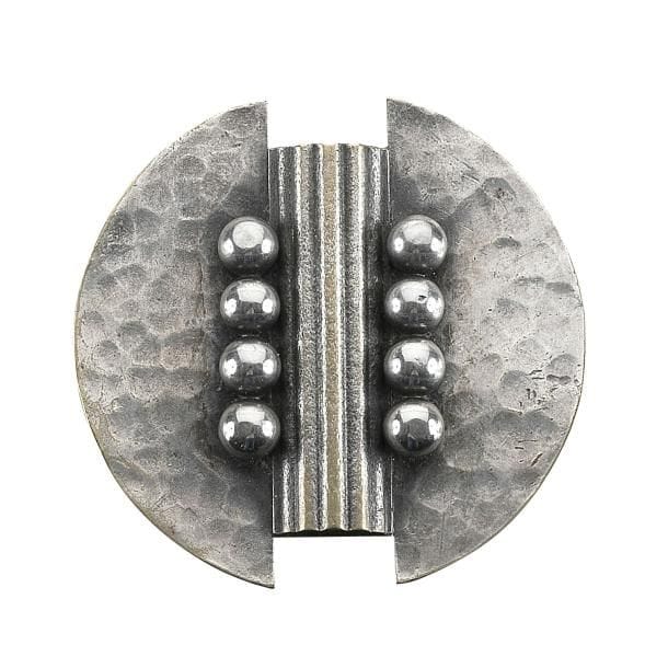 Jean DESPRÉS (1889-1980)
Rare broche moderniste en métal argenté.
La platine circulaire à deux échancrures et à surface entièrement martelée reçoit, en son centre un demi-cylindre cannelé, évoquant la tôle ondulée, encadré par deux rangs de quatre grosses sphères traitées lisses.
Altérations à l'argenture
Provenance :
Ancienne Collection M. & Mme F. (Thizy près d'Avallon - France), œuvre acquise par ces derniers directement auprès de l'artiste.