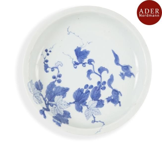 VIETNAM, Hue - XVIIIe siècle
Coupe en porcelaine décorée en bleu sous couverte de branche de vignes et deux loirs. (Ébréchures, marque gravée).
Diamètre : 20,4 cm