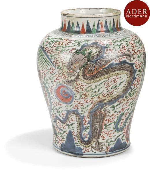CHINE - XVIIe siècle
Potiche en porcelaine à décor en émaux polychromes de phénix et dragons à la poursuite de la perle sacrée sur fond de flammèches, le col orné de motifs géométriques. 
(Manque le couvercle, importantes restaurations).
Hauteur : 33,5cm