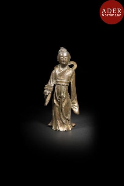 CHINE - Époque MING (1368 - 1644)
Statuette de jeune femme debout en bronze à patine dorée, tenant une fleur.
Hauteur : 14,5 cm