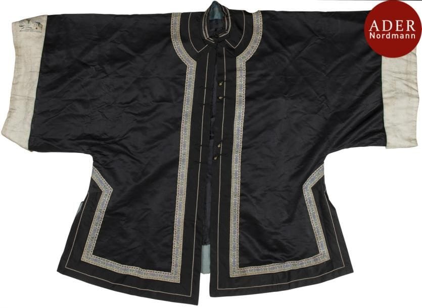 CHINE - XIXe siècle
Veste de femme en soie noire, les bords ornés de passementeries, les manches brodées aux fils polychromes de femmes dans un jardin.
Doublée de soie bleu clair. 
(Couleurs passées, usures et taches).
On y joint une veste d’homme en soie noire, doublée en soie bleu.
(Accidents)