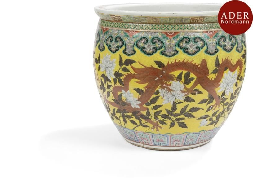 CHINE - Fin XIXe siècle
Grande vasque à poissons en porcelaine émaillée polychrome à décor de dragons s’affrontant sur fond jaune parmi les pivoines, l’intérieur orné de cyprins nageant parmi les algues. (Fêlures). 
Hauteur : 42 cm - Diamètre : 46 cm