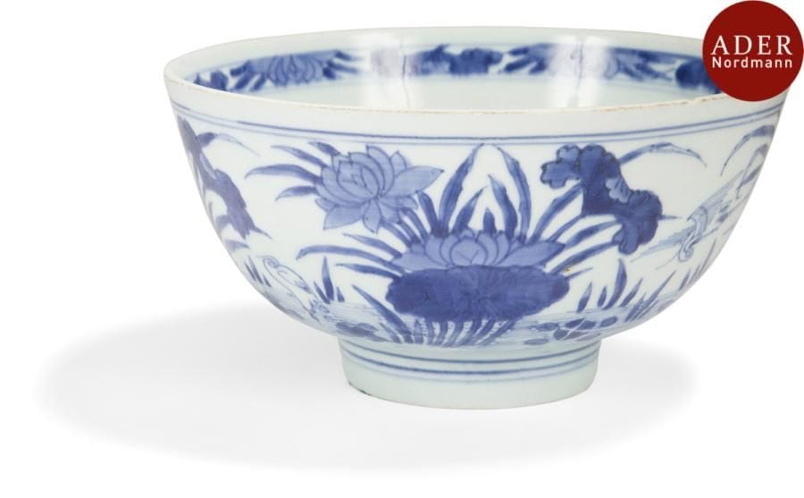 CHINE - Époque KANGXI (1662 - 1722)
Bol en porcelaine décorée en bleu sous couverte d’aigrettes parmi les fleurs de lotus. Marque apocryphe de Xuande. (Fêlure au talon, égrenure).
Diamètre : 20 cm
