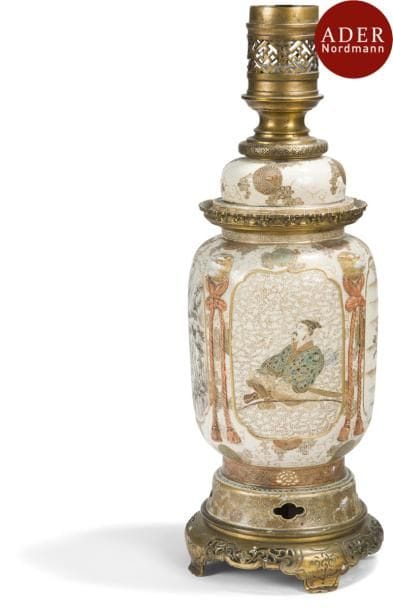 JAPON - Fours de Satsuma - Époque MEIJI (1868 - 1912)
Potiche en faïence de Satsuma à décor de personnages et de paysages dans des médaillons, sur fond de motifs géométriques et alternés avec des têtes de shishi tenant des cordelettes en relief. Montée en lampe.
Hauteur totale : 48,5 cm