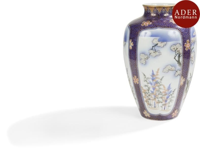 JAPON - Époque MEIJI (1868 - 1912)
Vase balustre en porcelaine décorée en bleu sous couverte et émaux polychromes de réserves ornées de cerisiers et forêts de bambous sur fond bleu nuit. Le col orné d’une frise de fleurs. Marque Fukagawa. 
Hauteur : 34 cm