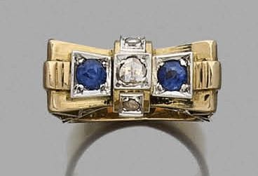 Bague en or rose 18K (750‰) à plateau incurvé serti de deux pâtes de verre bleu, appliqué d’une barrette sertie de diamants taillés en roses.
Travail des années 1940.
Tour de doigt : 55/56. Poids brut : 12,5 g