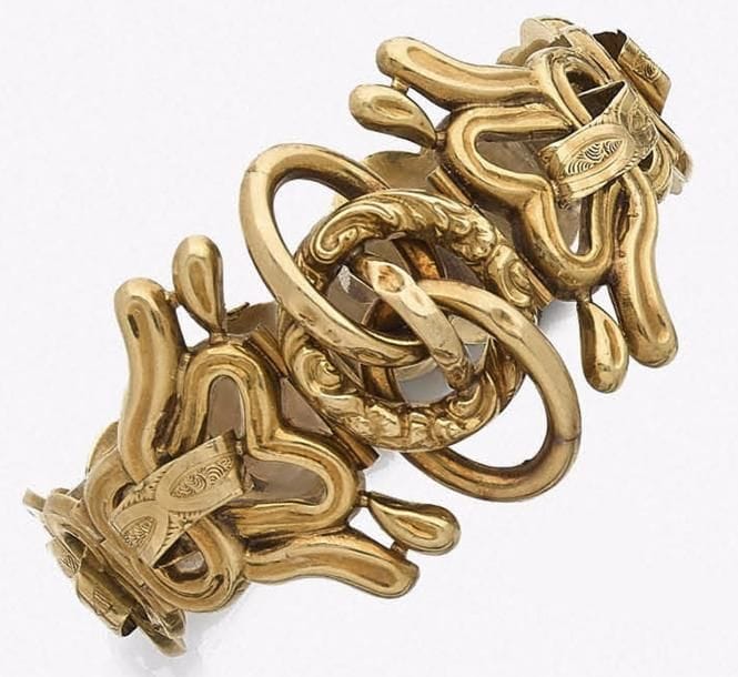 Bracelet articulé en boucles d’or 18K (750‰) et motifs imbriqués.
Travail français du milieu du XIXe siècle.
Longueur : 18,3 cm environ. Poids : 41 g
(on joint un maillon supplémentaire, enfoncements) 
